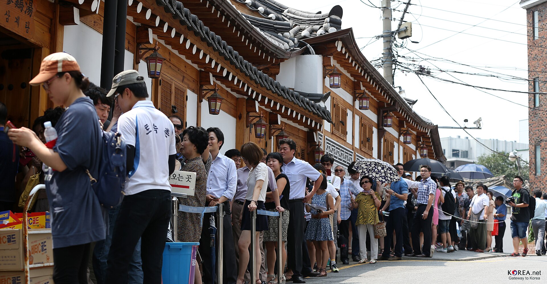 한글 간판이 있는 한국 식당 앞에서 입장을 기다리는 긴 대기 행렬