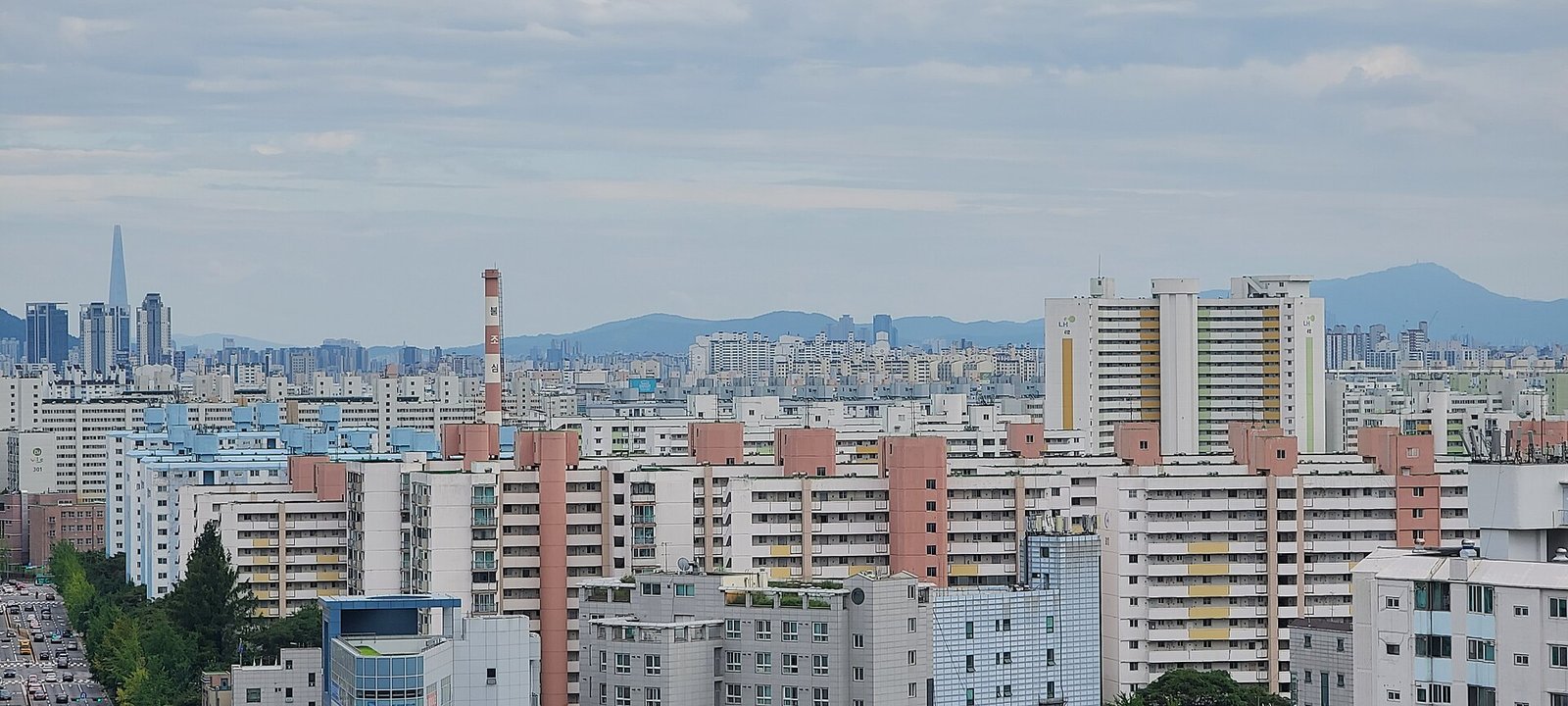 높은 곳에서 내려다본 서울 노원구의 아파트 단지들. 흰색과 분홍색 줄무늬의 고층 아파트가 빽빽하게 늘어서 있고 멀리 산이 보인다